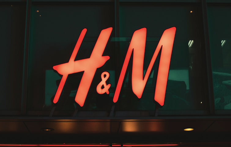 ein rotes Plakat der Marke H&M, die immer mehr umweltfreundliche Kollektionen anbietet