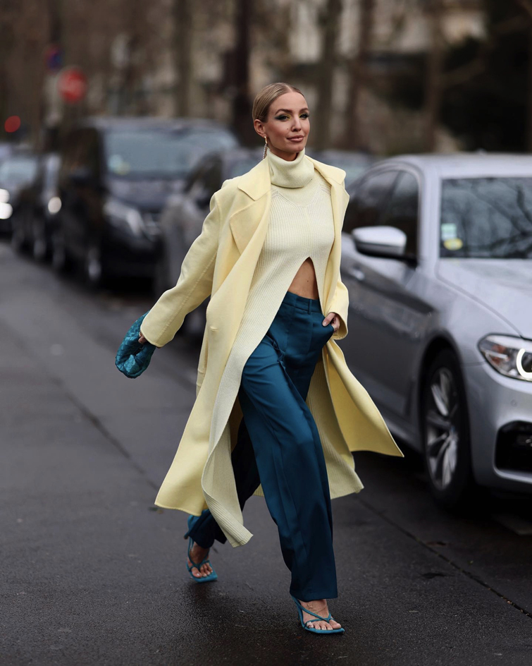 eine der wichtigste Influencer Deutschland: Leonie Hanne fotografiert, wie sie in einem bunten gelb-blauen Outfit durch die Straßen läuft