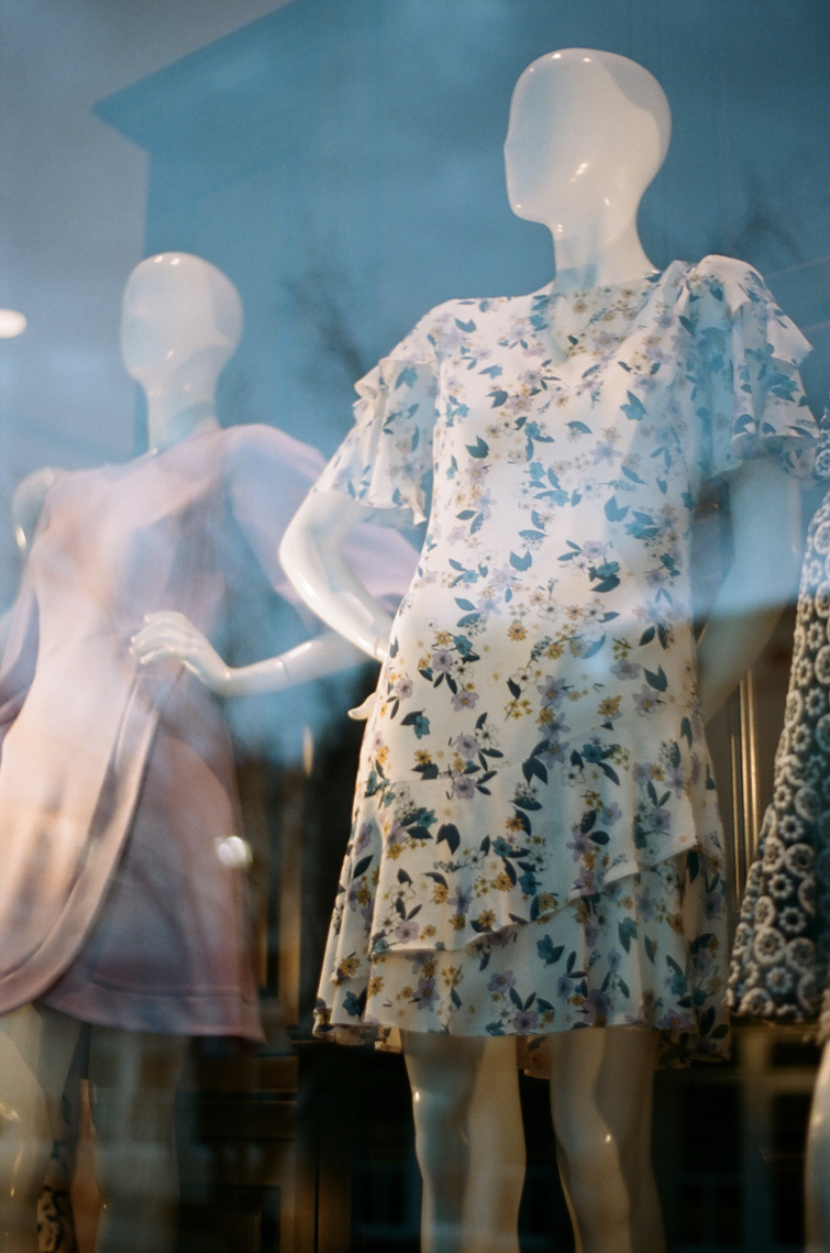 Second Hand Kleidung Shop in Nürnberg Schaufenster. Kleider mit Blumen, die von Models getragen werden