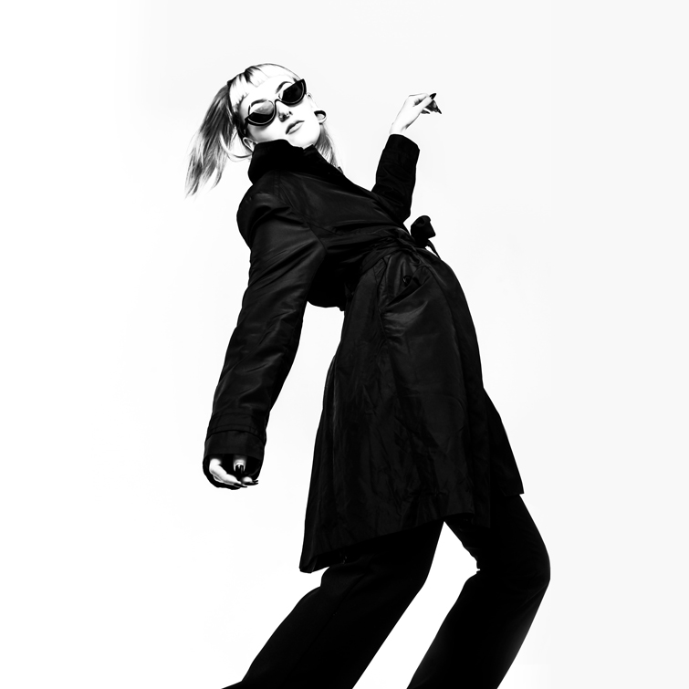 Schwarz-Weiß-Foto einer Frau, die einen schwarzen Total Look trägt